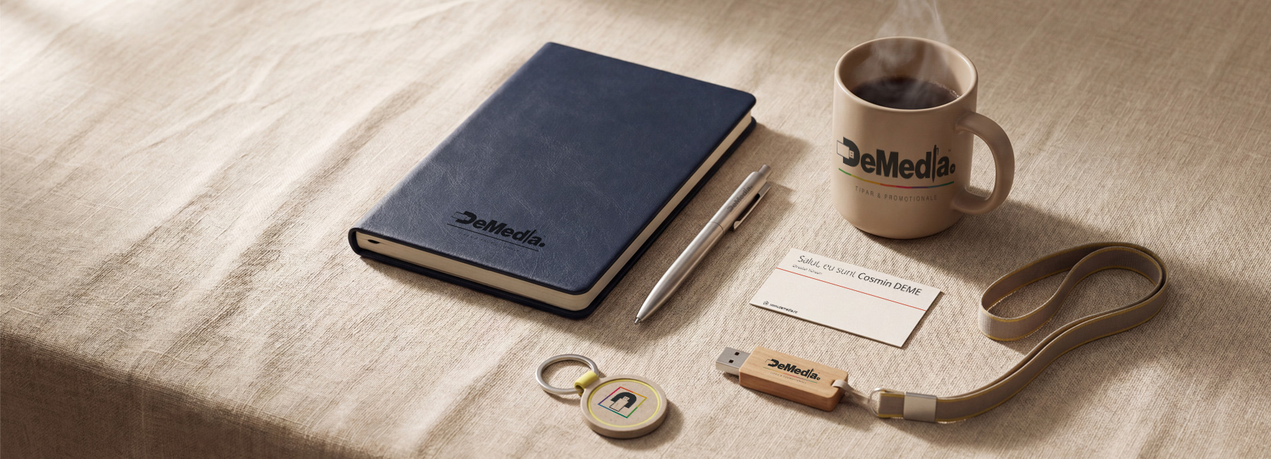 Set produse promoționale personalizate cu siglă companie pe birou: pixuri metalice, agendă, cană, USB, breloc